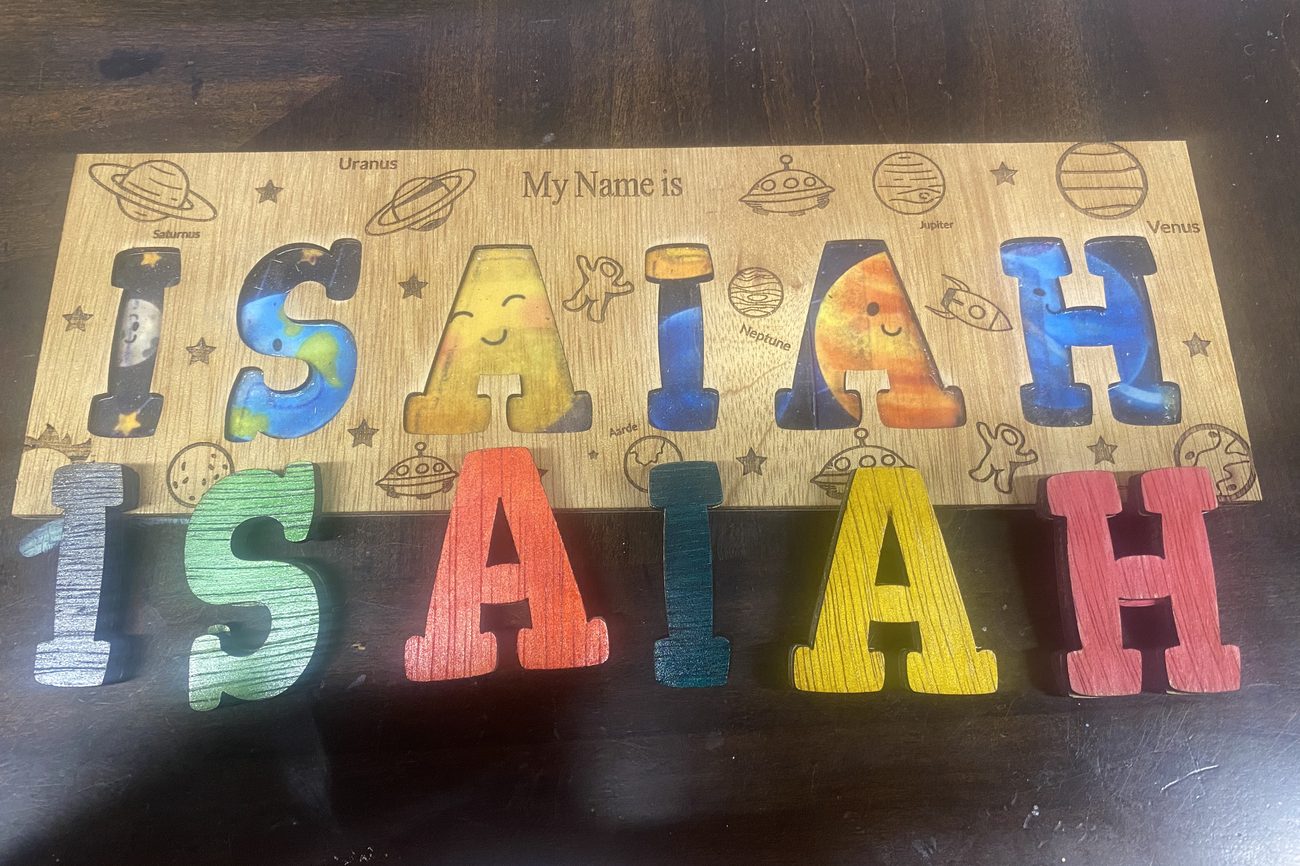 Wooden name puzzle spelling Isaiah with space themed letters